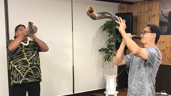 A person holding a horn to another person