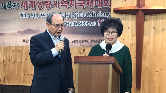 A person and person standing at a podium with microphones