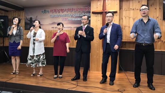 A group of people singing on a stage