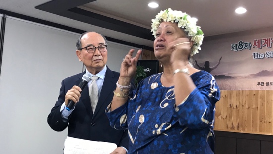 A person in a blue dress with a flower crown on her head