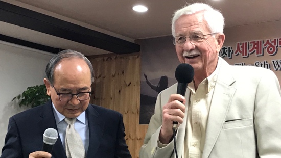 Two men in suits holding a microphone