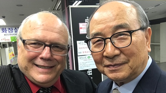 Two men wearing glasses and smiling