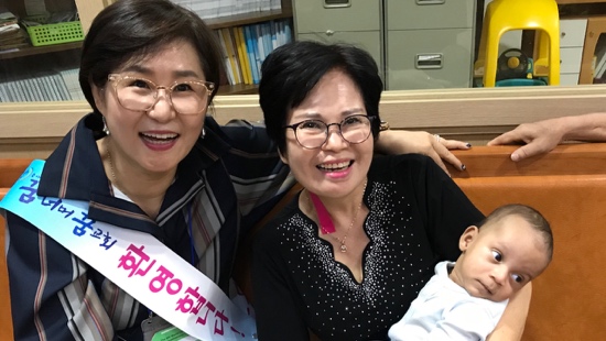 A group of women smiling with a baby