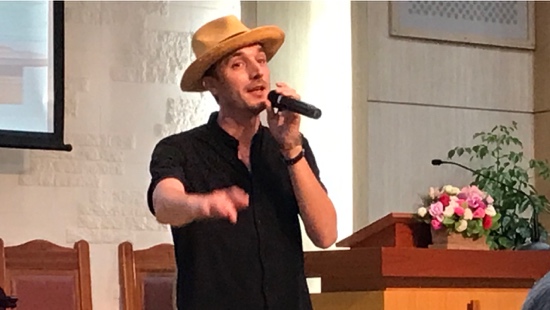 A person wearing a hat and holding a microphone
