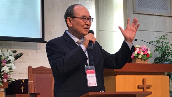 A person in a suit speaking into a microphone