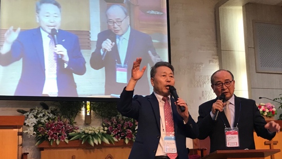 A group of men in suits speaking into microphones