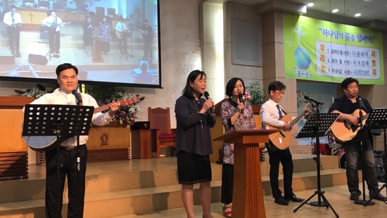 A group of people singing and playing instruments