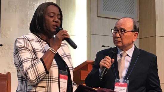 A person holding a microphone and a person in a suit