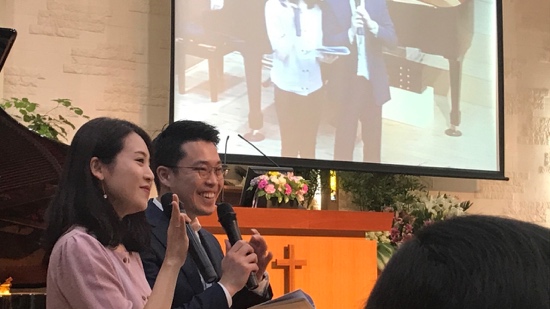 A person and person standing in front of a screen