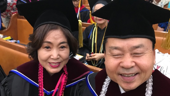 A person and person wearing graduation caps and gowns
