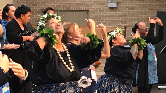 A group of women wearing leis and flowers