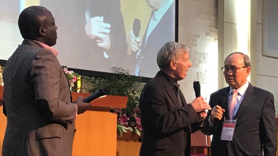 A person holding microphones in front of a screen