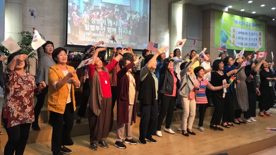 A group of people standing on a stage raising their hands