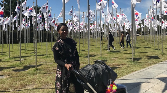 A person standing in front of a row of flags