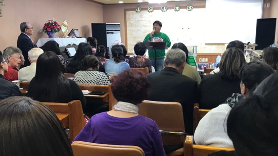 A person standing in front of a podium with a crowd of people