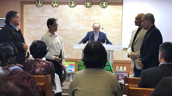 A person standing in front of a podium with a person standing in front of a group of people