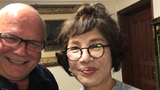 A person wearing glasses and a person wearing a blue shirt