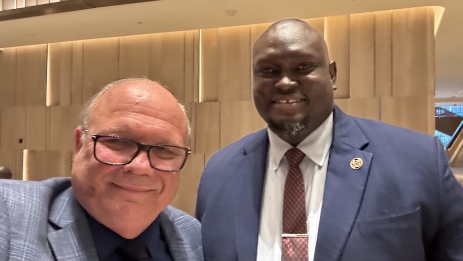 Two men in suits smiling