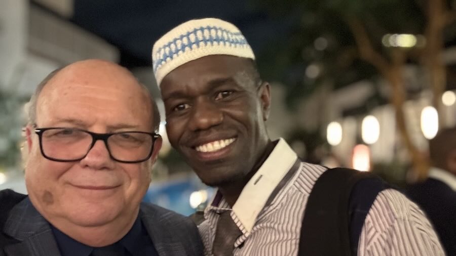 A person smiling next to another person