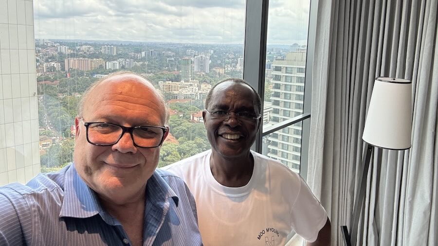 Two men standing in front of a window
