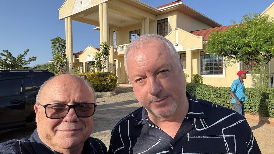 Two men taking a selfie in front of a house