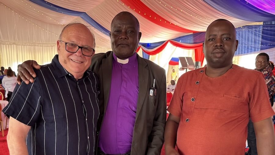 A group of men standing under a tent