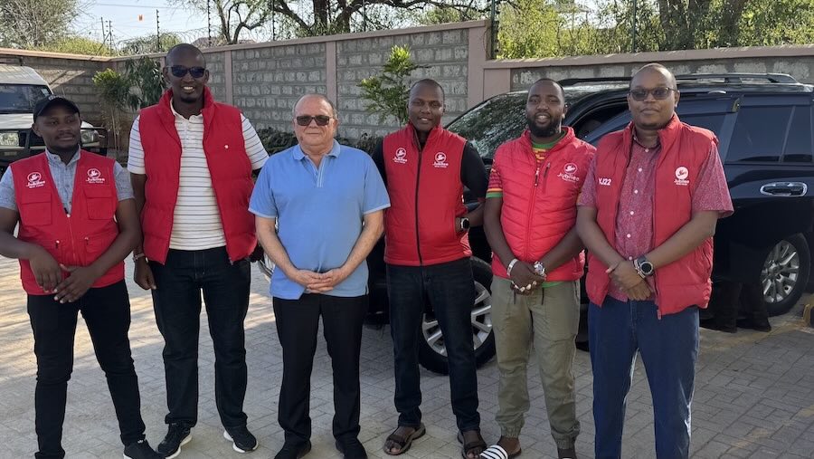 A group of men standing in front of a car