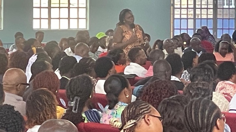 A person sitting in a room with a group of people
