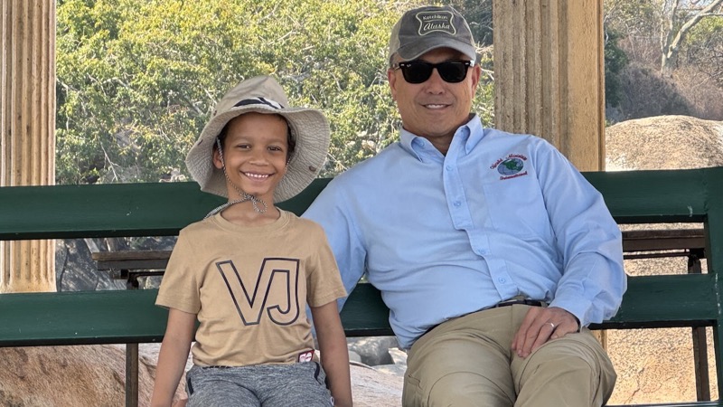 A person and child sitting on a bench
