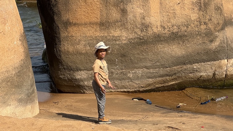 A child standing in front of a rock wall