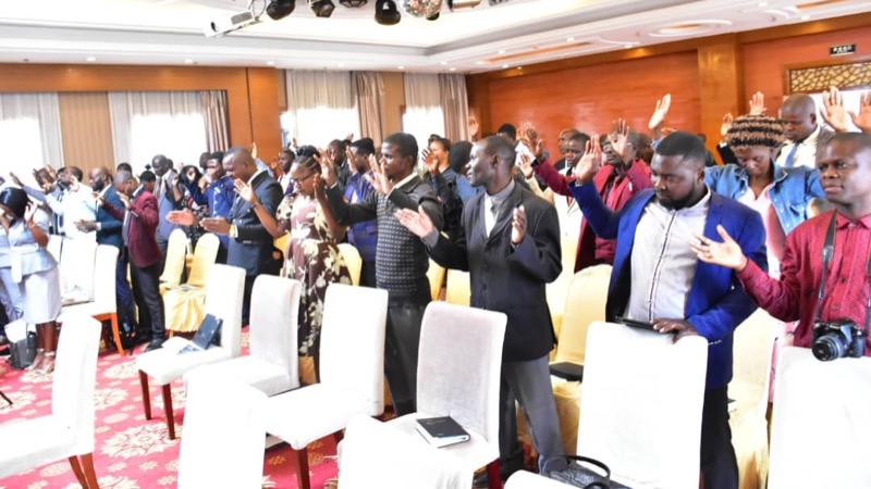 A group of people clapping in a room