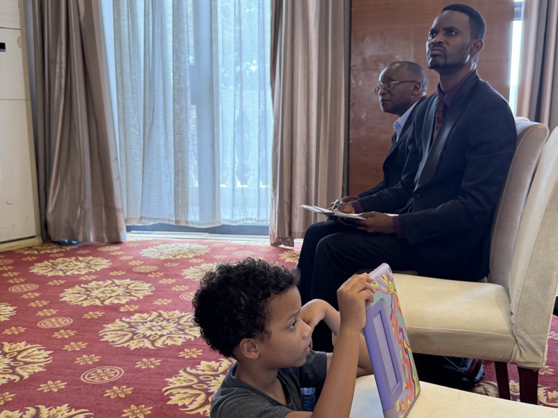 A person sitting on a couch with a child in front of him