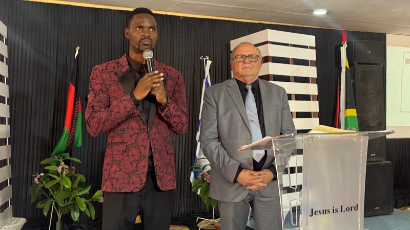 A person standing next to a person holding a microphone