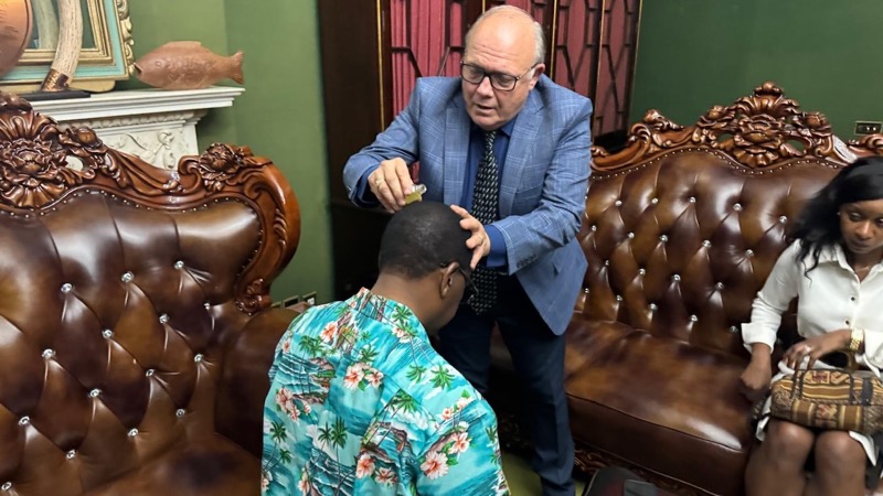 A person in a suit and tie combing a person's head