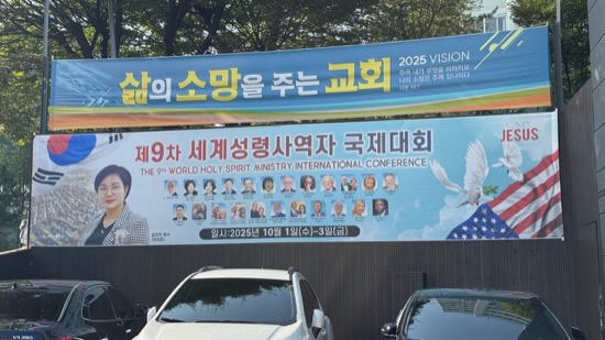 A sign with a couple of cars parked in front of it