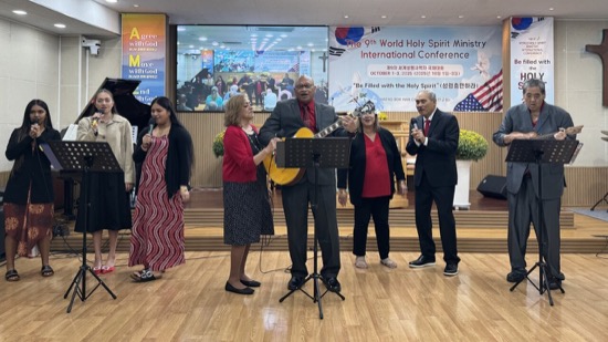 A group of people standing around a person playing a guitar