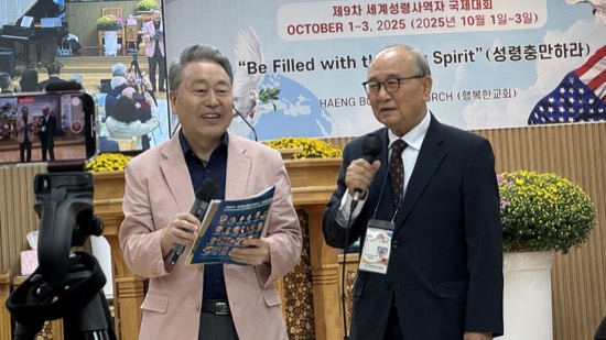 Two men holding microphones in front of a table