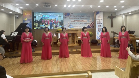 A group of women in red dresses on a stage