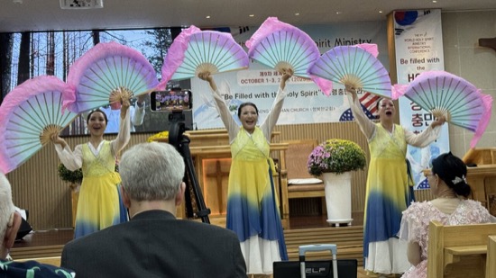 A group of women in dresses holding fans
