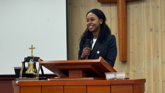 A person standing at a podium holding a microphone
