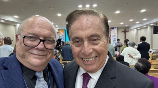 Two men in suits smiling