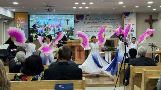 A group of women in white dresses with pink and blue wings