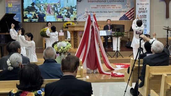 A person standing on a stage with a red and white cloth