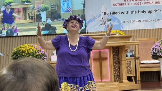 A person in purple dress with her arms up