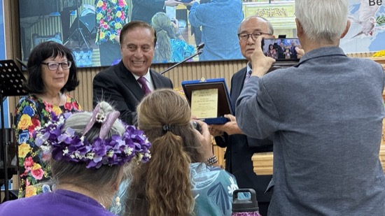 A person taking a picture of a person holding a certificate