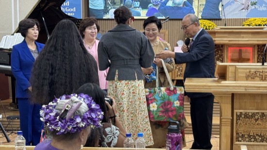 A person in a suit talking to a person in a crowd