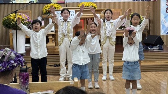 A group of children in white shirts and blue jeans