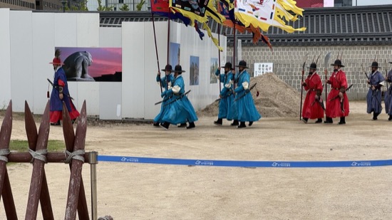 A group of people in blue uniforms holding flags