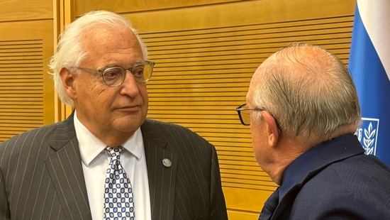 A person in a suit talking to another person