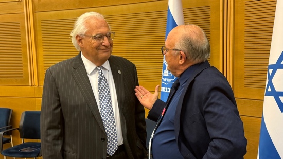 A person in suit talking to another person